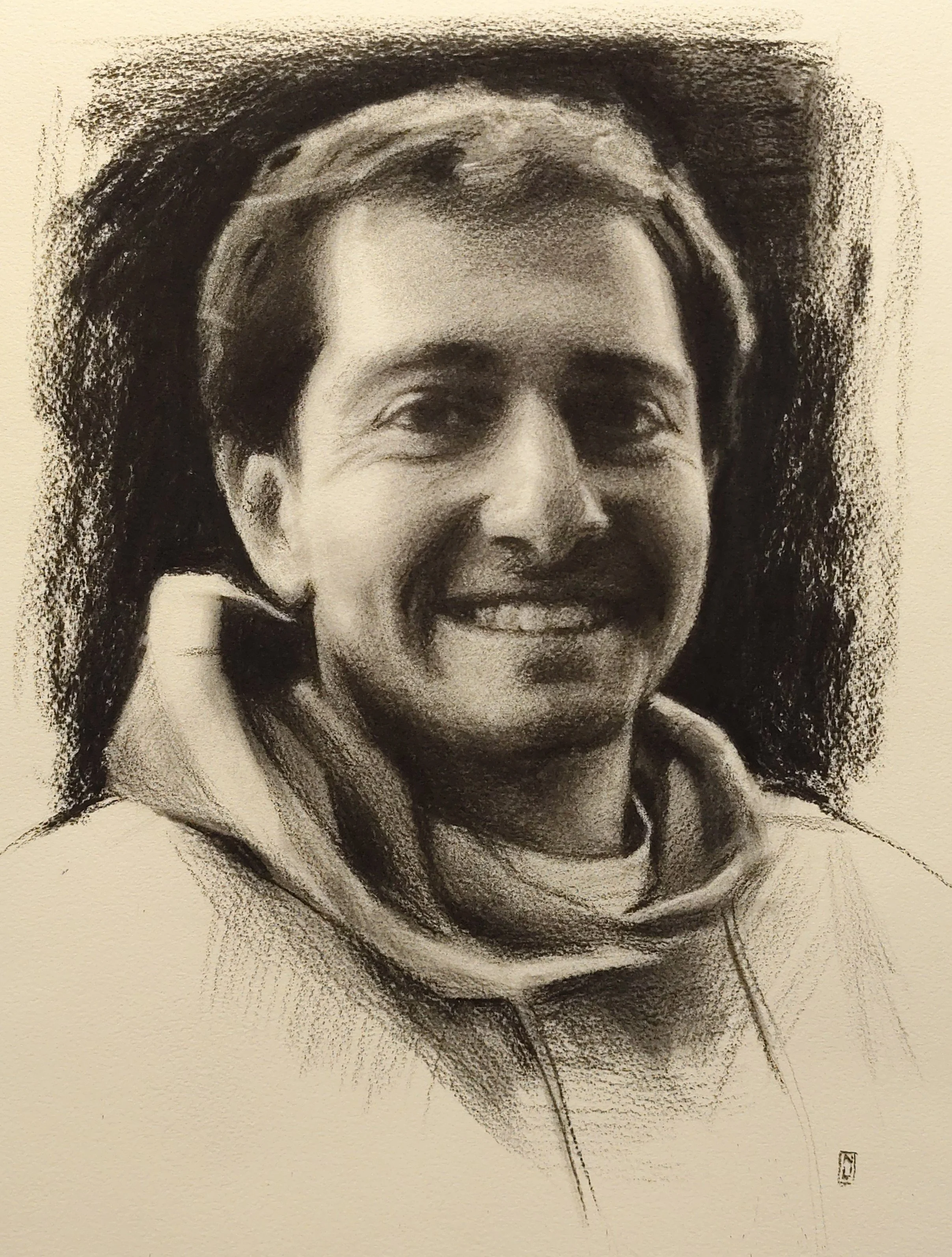 A detailed black and white portrait of a smiling person wearing a hoodie and headband.