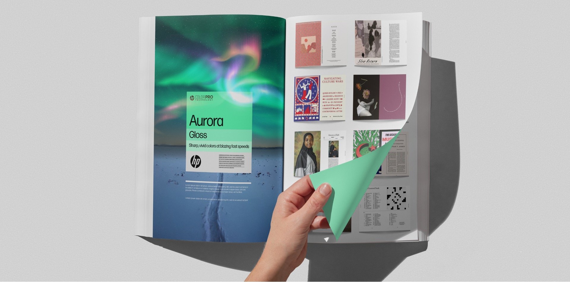 A person is flipping through a magazine on a white surface, revealing a page about the Aurora, with an image of the northern lights over water and the text 'Aurora Gloss'.