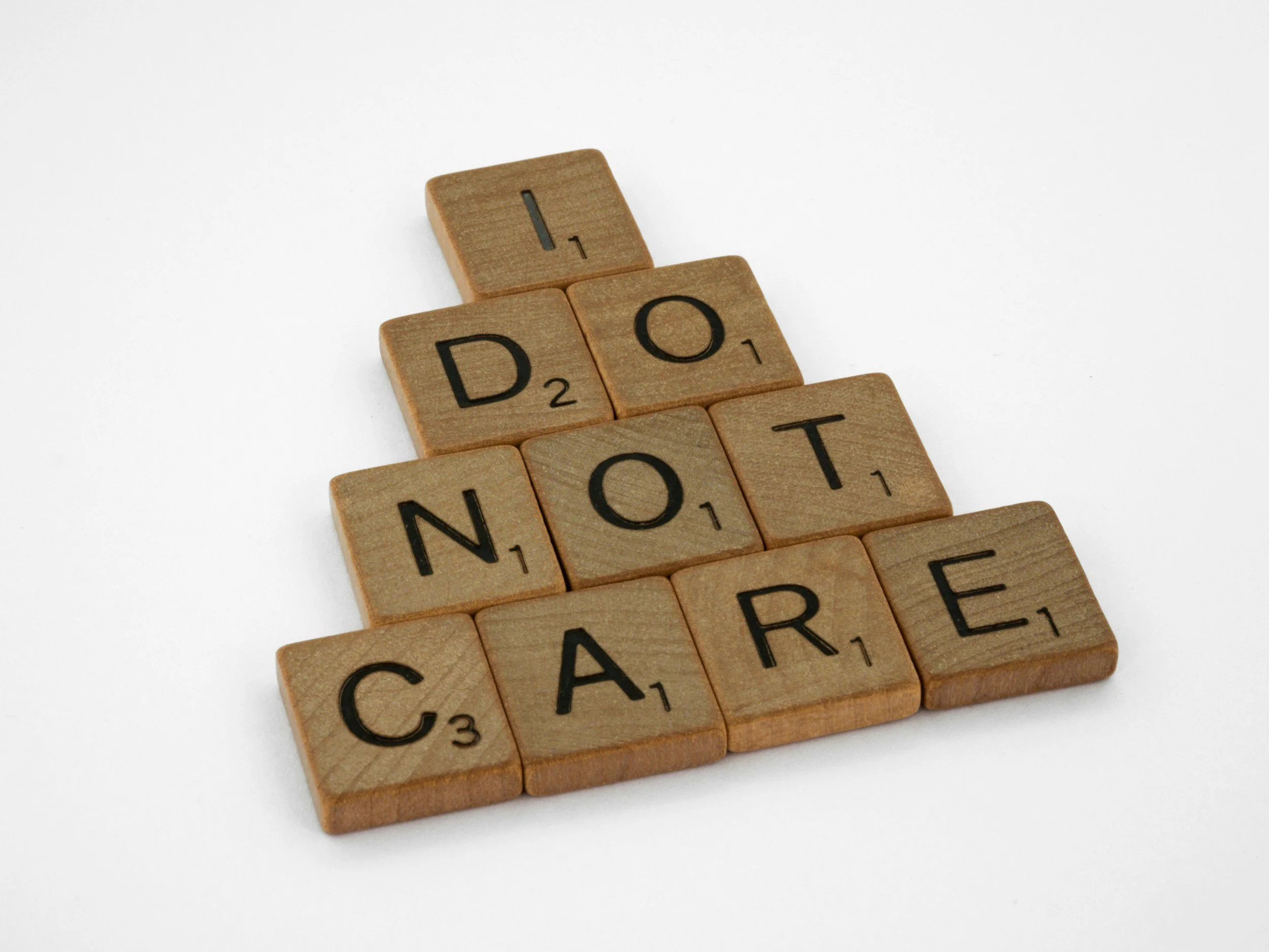 Wooden letter tiles spell "I do not care" on a white background, which federal employees may think is the attitude of their Human Resources staff.