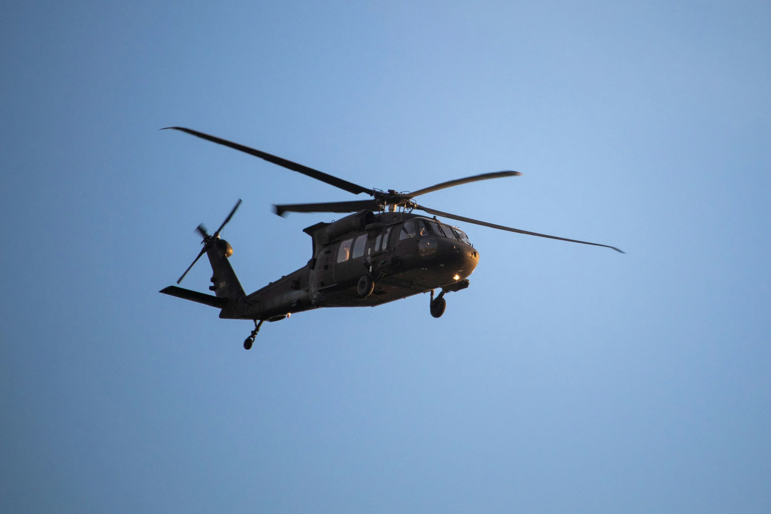 A U.S. Army Black Hawk helicopter in flight against a clear blue sky, representing the Army Special Forces soldier who was charged with using classified military information to place bets on the Polymarket, a prediction market platform.