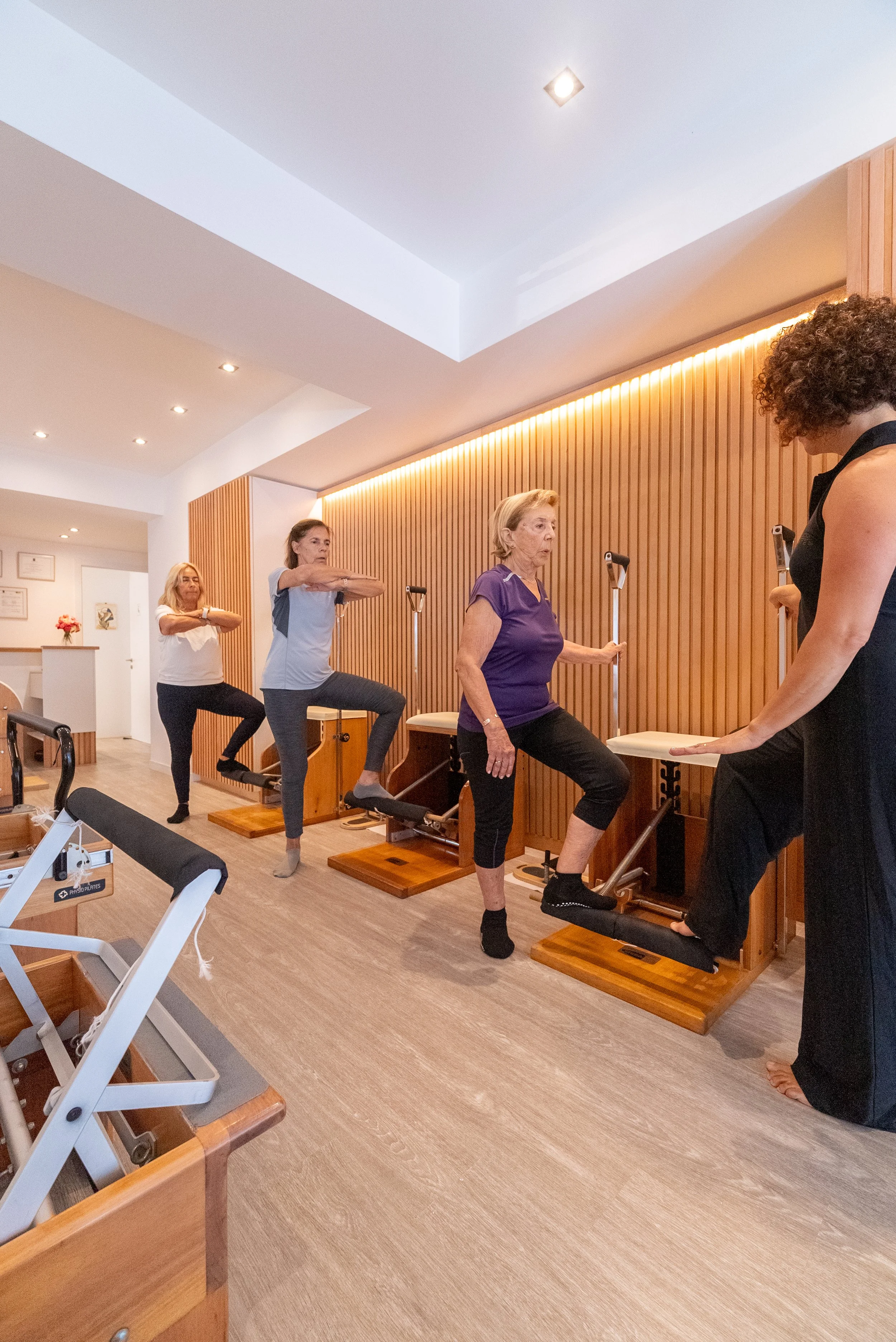 Stack of wooden and bamboo cutting boards with black plastic rubber grips on top, inside a cabinet or shelf.