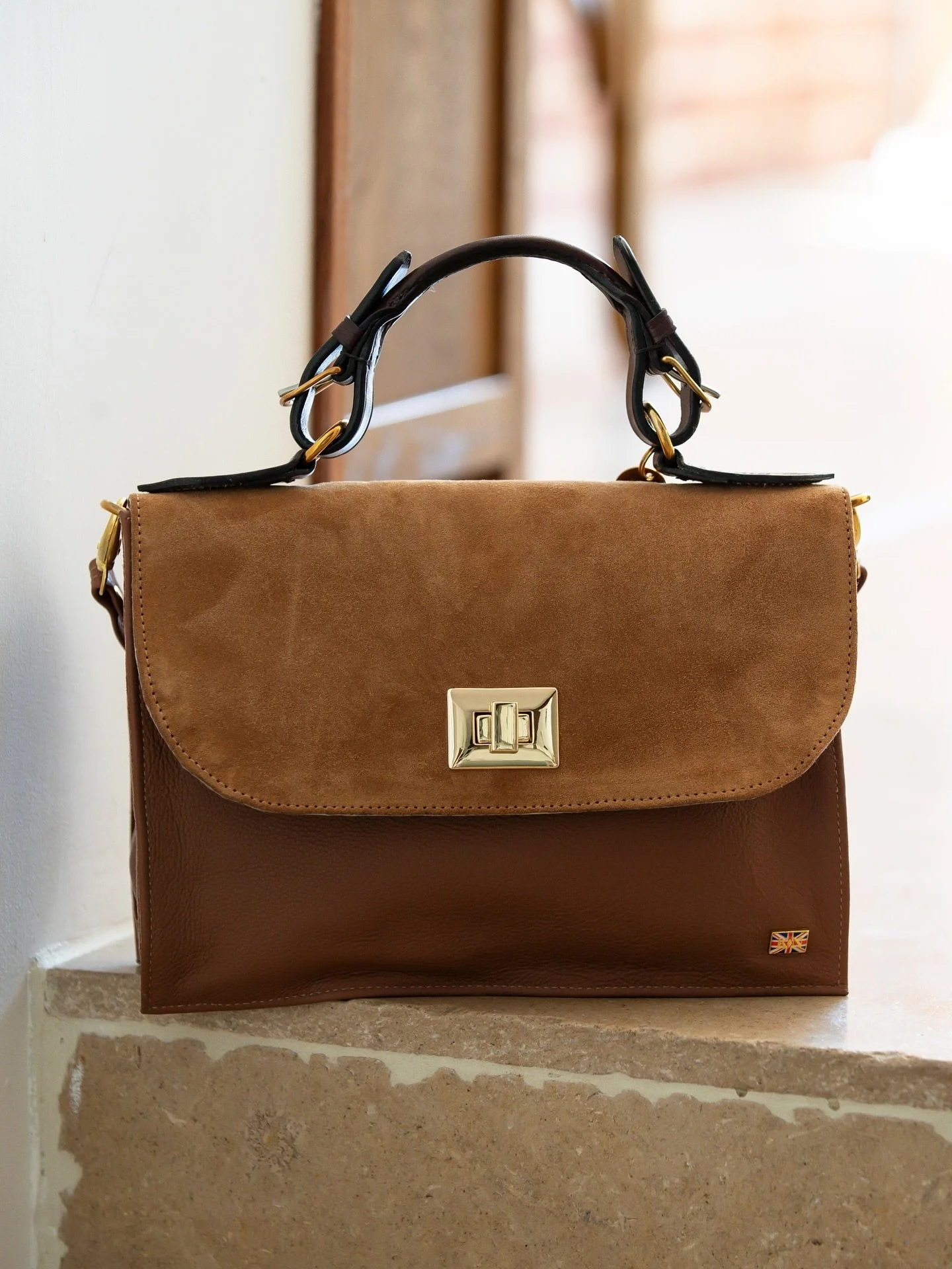 A refined blend of elegance and versatility, the KN Cheltenham bag is designed to adapt beautifully to every occasion. 

It features a rolled leather top handle, along with both a matching adjustable leather strap and a gold chain shoulder strap - al