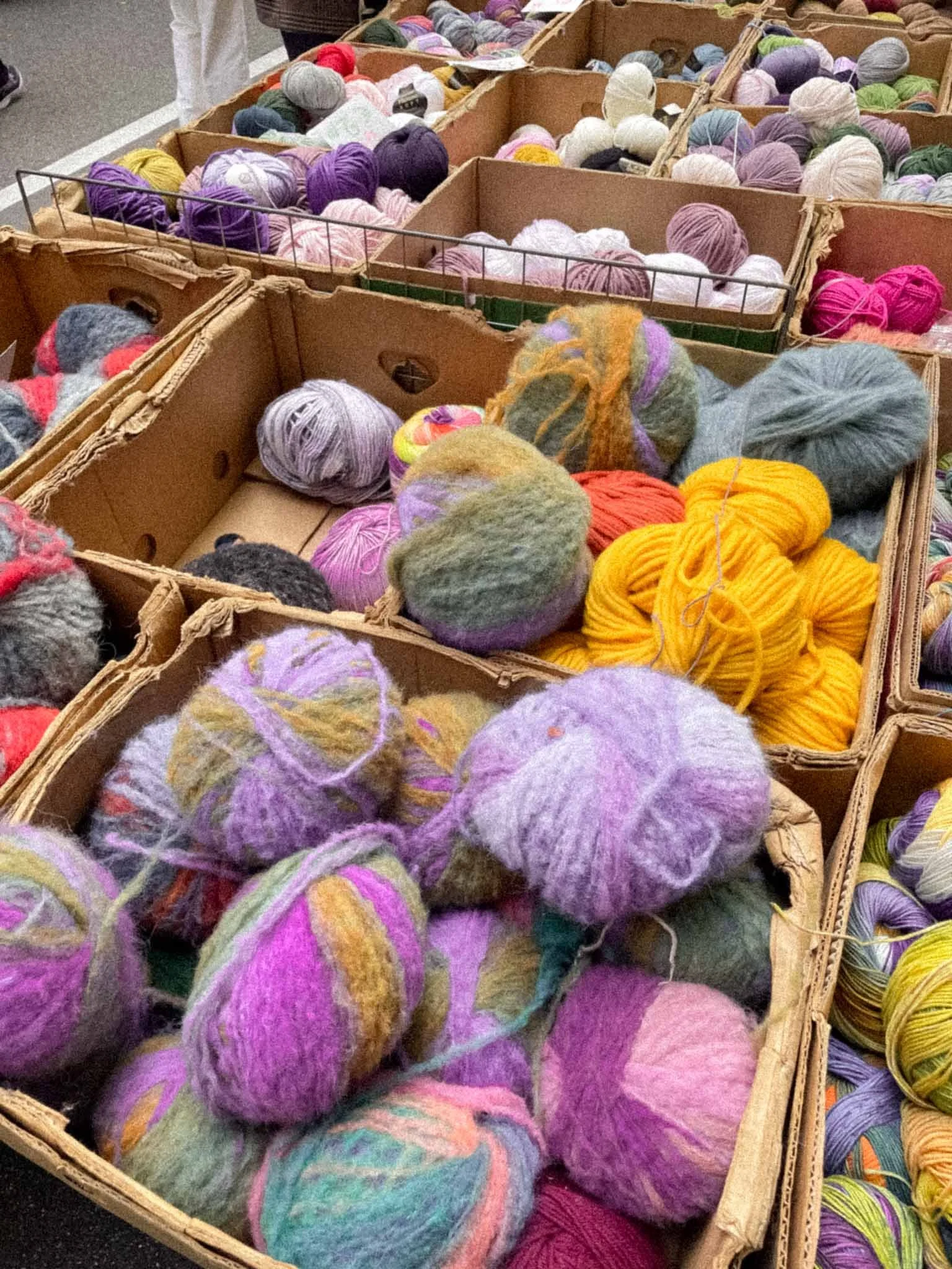 Baskets of colorful yarn balls at a craft store or market.