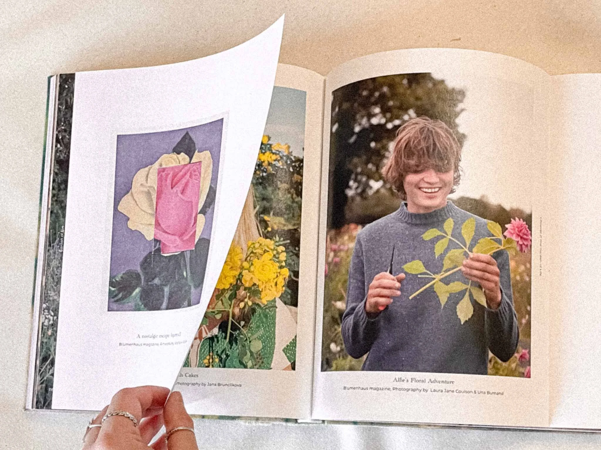 Open magazine showing two pages: left page features an abstract art piece with various colors; right page shows a woman smiling outdoors, holding a branch with yellow and pink flowers, next to bouquets of flowers, with text indicating it's from Bumen