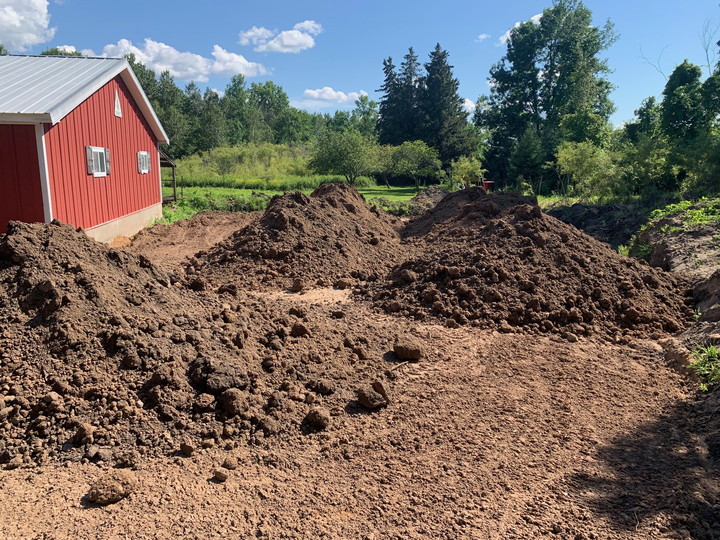 Fill to smooth out grading for new parking pad alongside the garage. 
