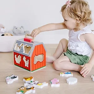Young girl playing with a wooden animal shape puzzle and stacking pieces on a table