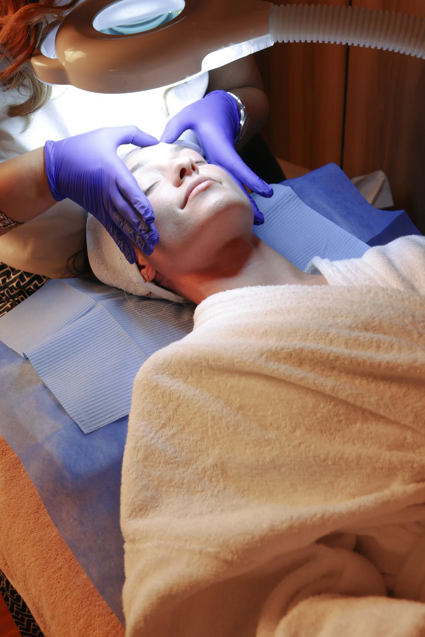 Customer getting her face examined by professional facial consultant