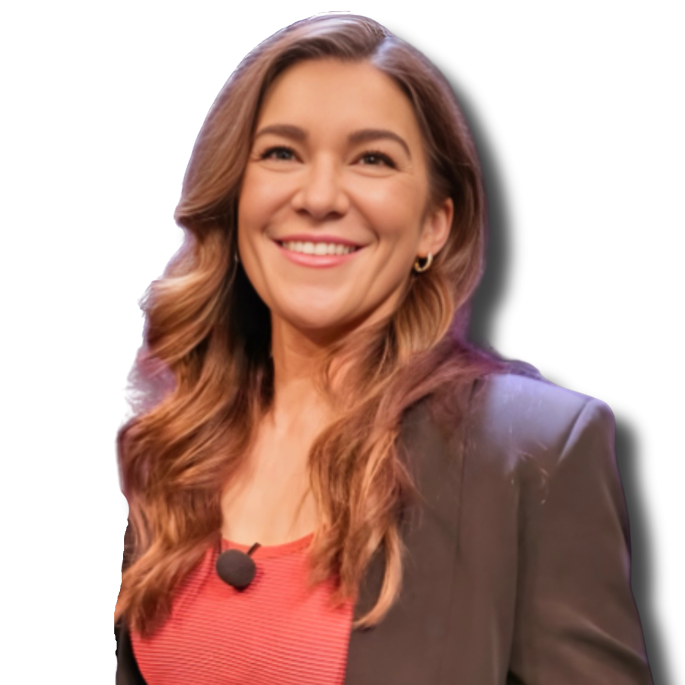 A smiling woman with wavy, shoulder-length hair wearing a black blazer and red top with a black lapel microphone.
