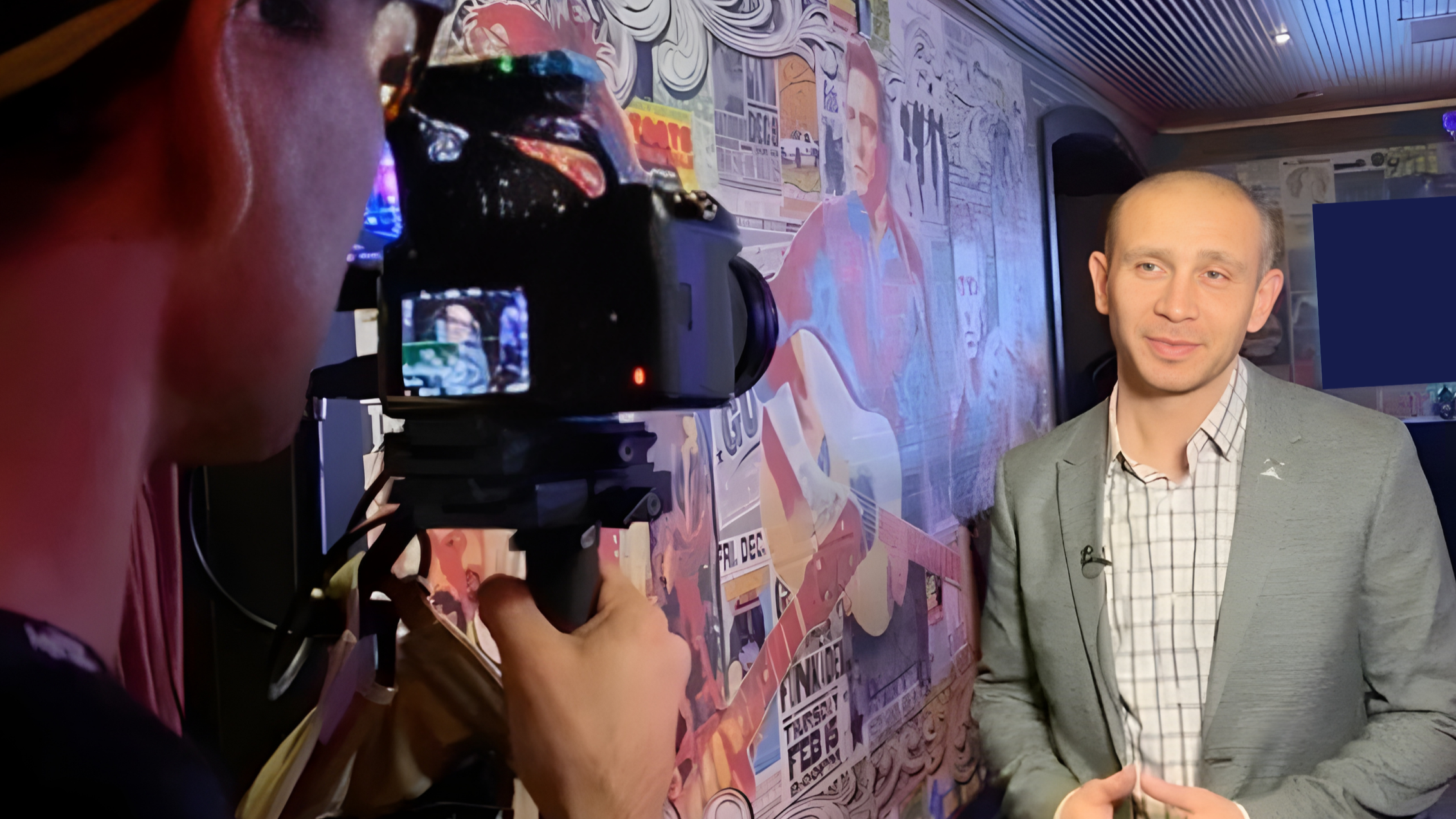 Pasha Palanker being interviewed for a live tv interview and a cameraman shooting as Pasha speaks