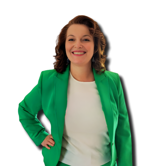 A woman with wavy brown hair smiling, wearing a bright green blazer over a white top, standing with one hand on her hip.