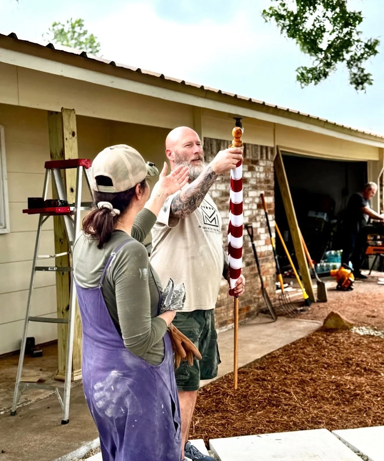 Patrick and Maria Reed unfurling the American flag after a home makeover