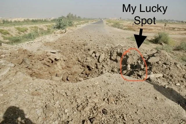 A dirt road with a small rock formation labeled 'My Lucky Spot' and an arrow pointing to it, in a dry, barren landscape.