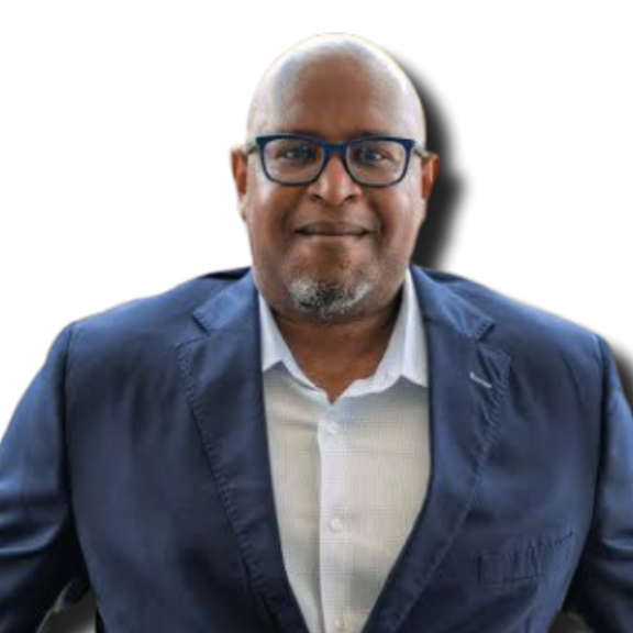 A middle-aged man with glasses, a goatee, and a bald head, wearing a blue blazer and a white shirt, smiling at the camera.