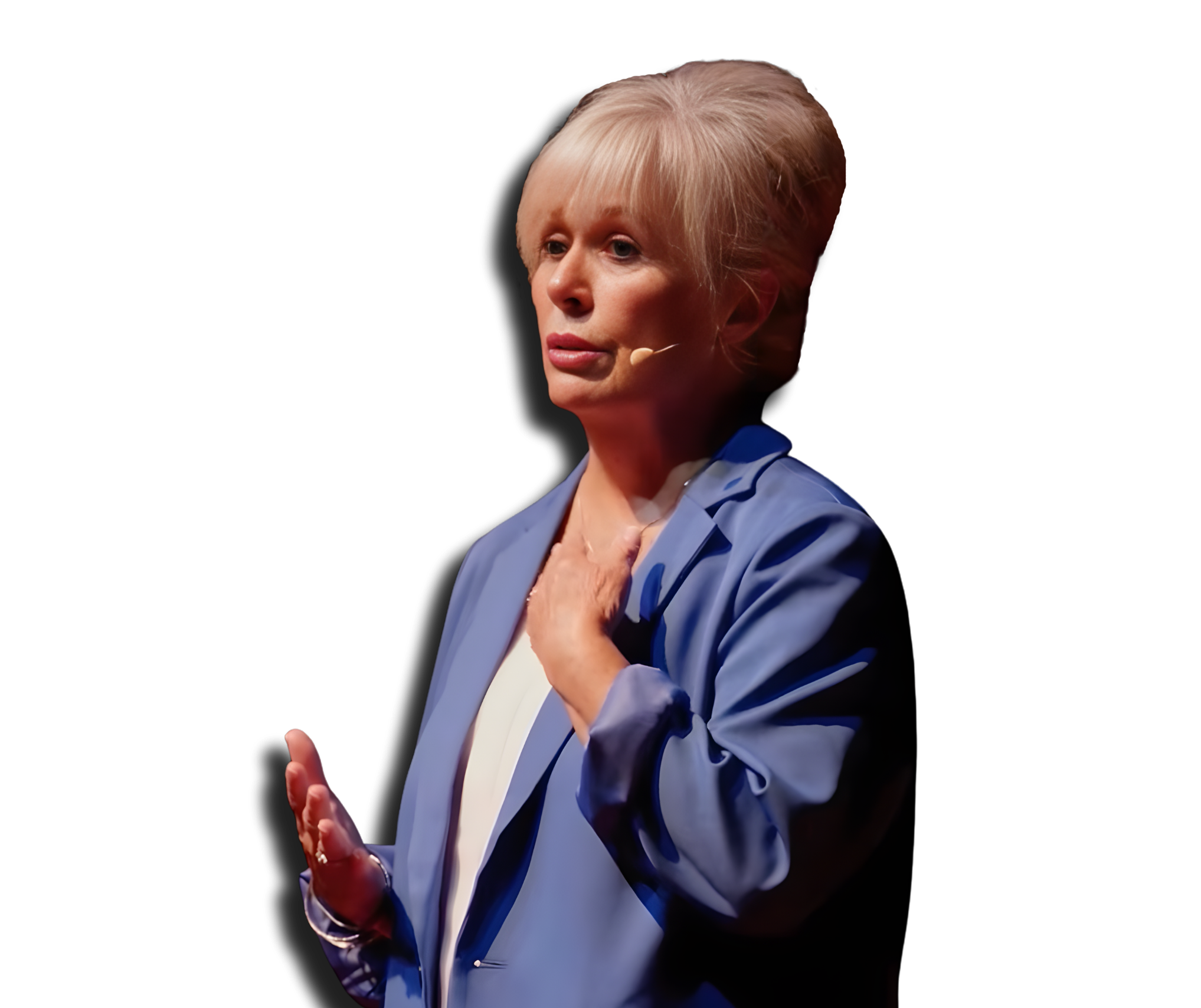 A woman with short blonde hair wearing a blue blazer and white shirt, speaking on stage with a headset microphone, gesturing with her hands.
