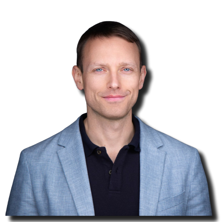 Portrait of a man with short brown hair and blue eyes, wearing a light grey blazer over a black polo shirt, smiling slightly against a black background.