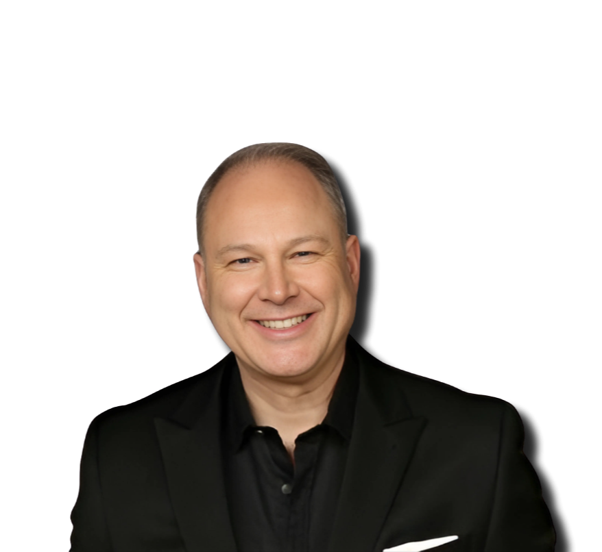 A smiling middle-aged man with short hair wearing a black suit jacket and black shirt, against a black background.