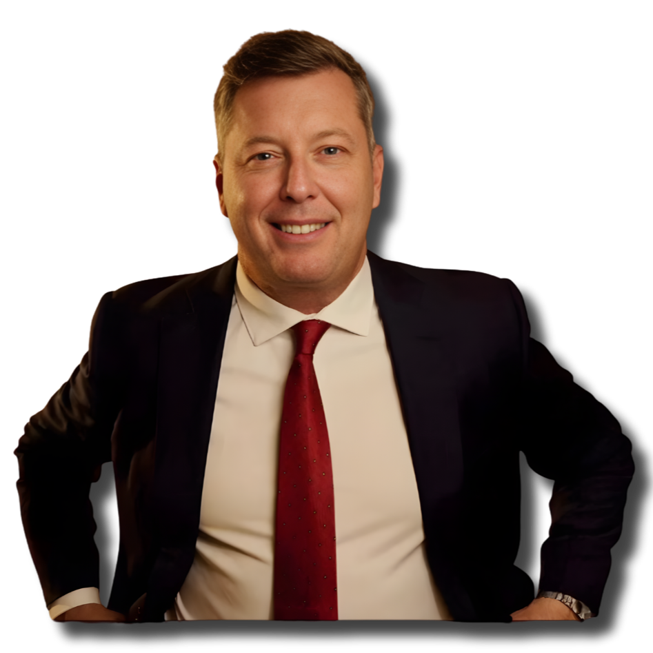 A smiling man in a business suit with a red tie, posing with one hand on his hip against a black background.