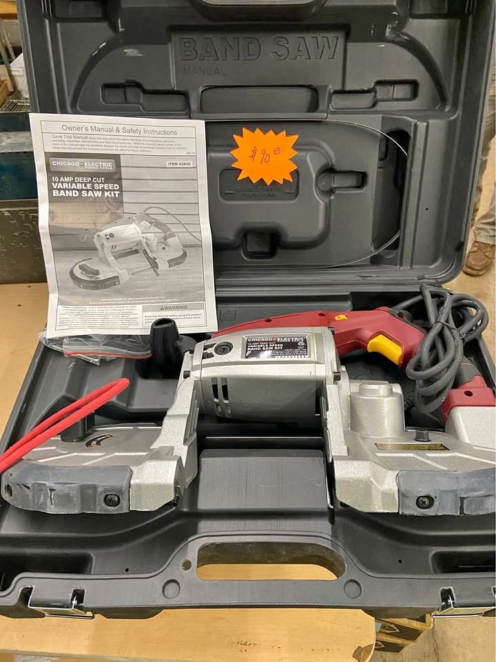 A deep cut variable speed band saw kit inside an open black plastic case. The saw is silver with a red handle and a yellow power switch. There's a user manual on top of the saw and an orange price tag indicating $78.00.