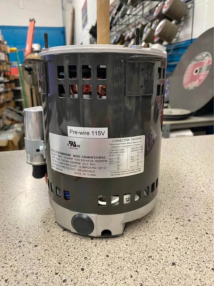 Air compressor motor with connection diagram and a label marked 'Pre-wire 115V' on a workbench at a hardware store.