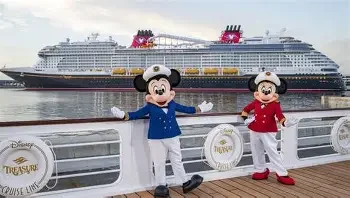 Mickey Mouse plush toys dressed as sailors on a cruise ship promenade with a large cruise ship in the background.