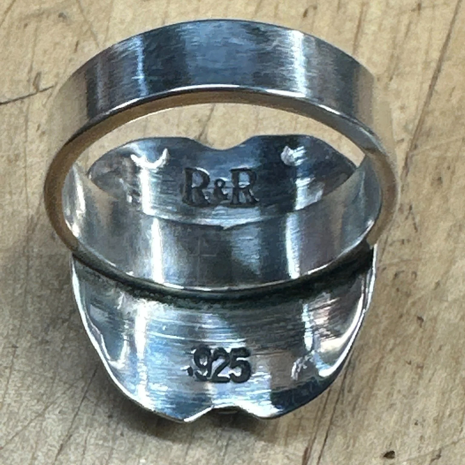 Turn it over. If there's nothing stamped inside, ask why.

Every piece that leaves this bench gets two marks: R&amp;R, and 925.

The 925 means sterling &mdash; 92.5% silver, the standard for anything that has to survive being worn. The R&amp;R is min