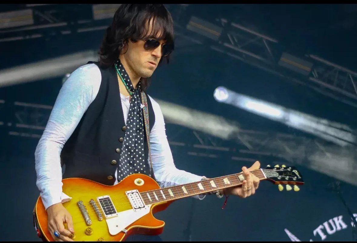 Tobin Dale playing a sunburst les paul onstage.