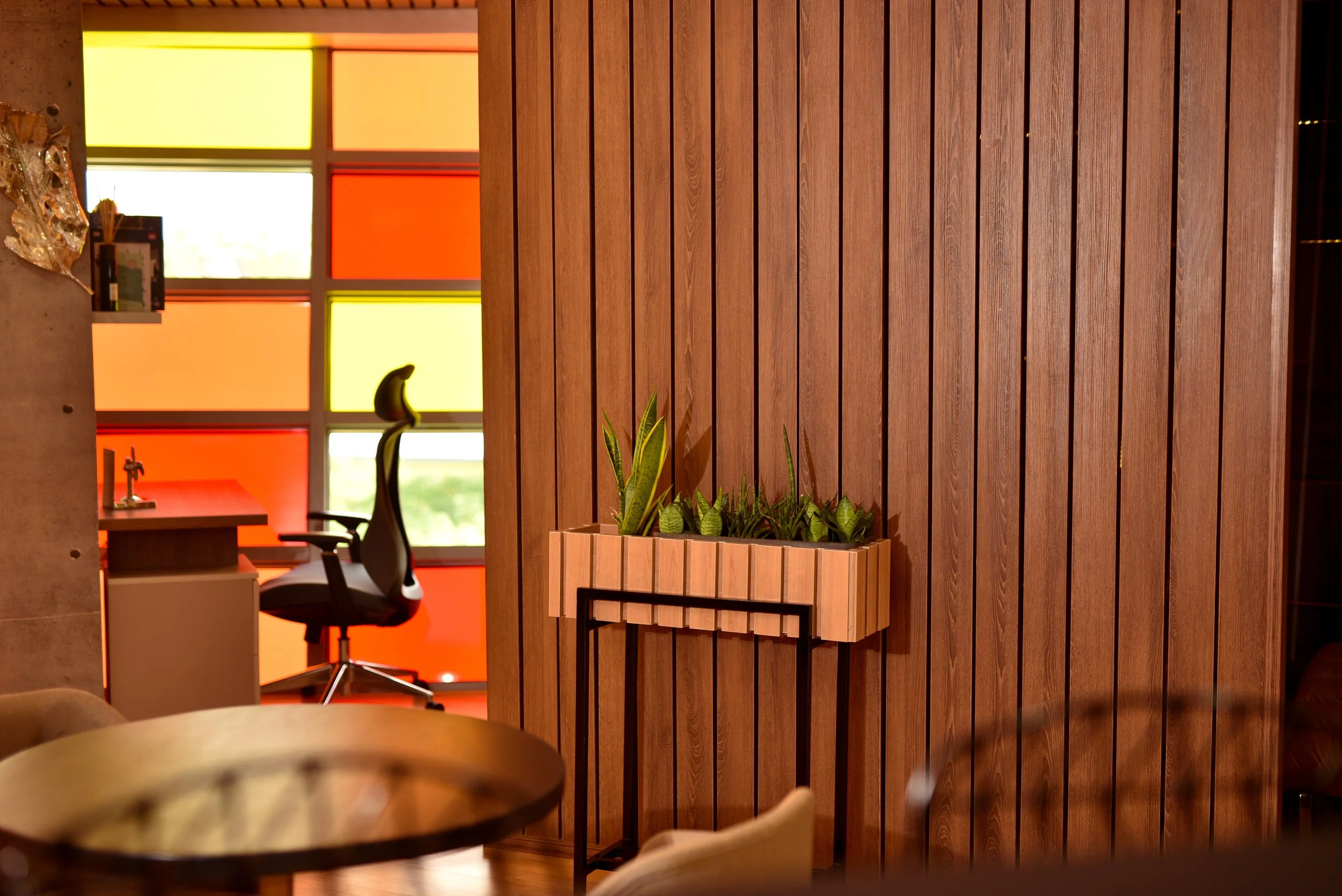 Transition zone combining acoustic timber paneling and biophilic elements to ease movement between focused work and relaxation are