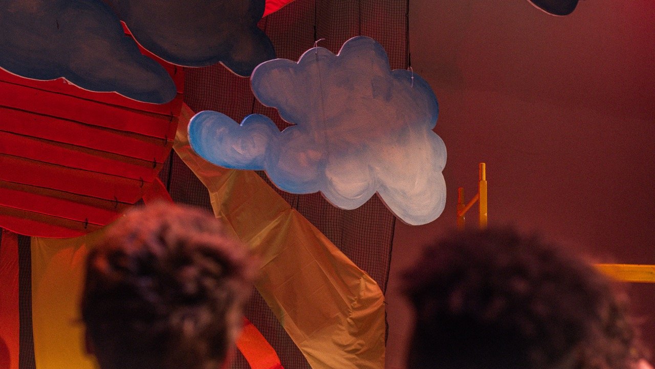 Colorful cloud and hot air balloon decorations seen from below in an indoor setting.