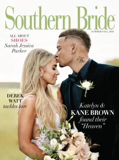 Cover of Southern Bride magazine featuring a bride and groom embracing, the groom is kissing the bride on the forehead while she holds a bouquet of white flowers.