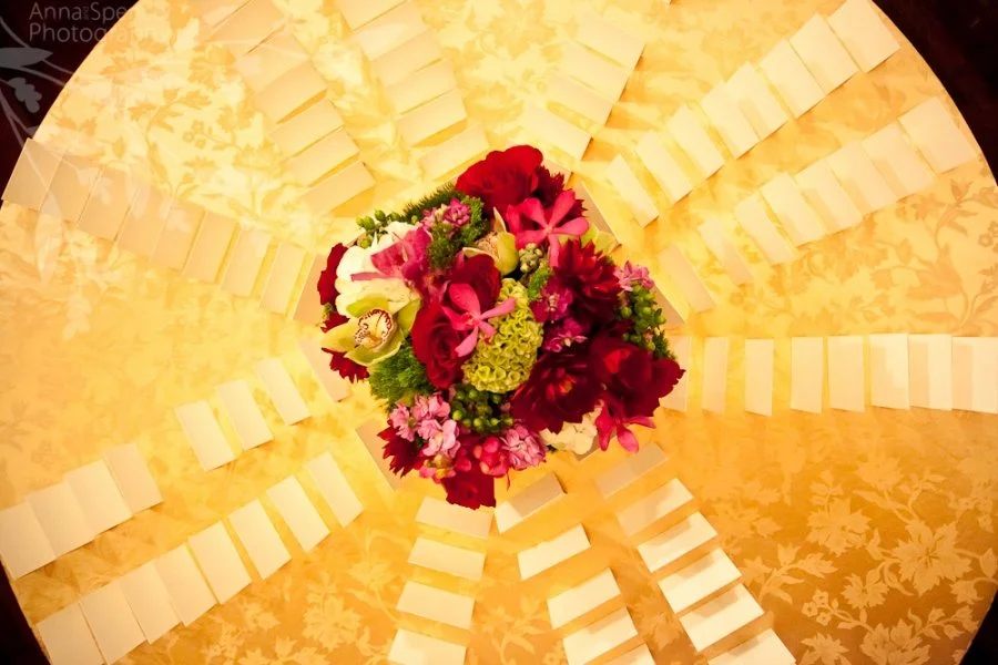 Top view of a bouquet of red, pink, and white flowers on a decorative yellow and gold background.