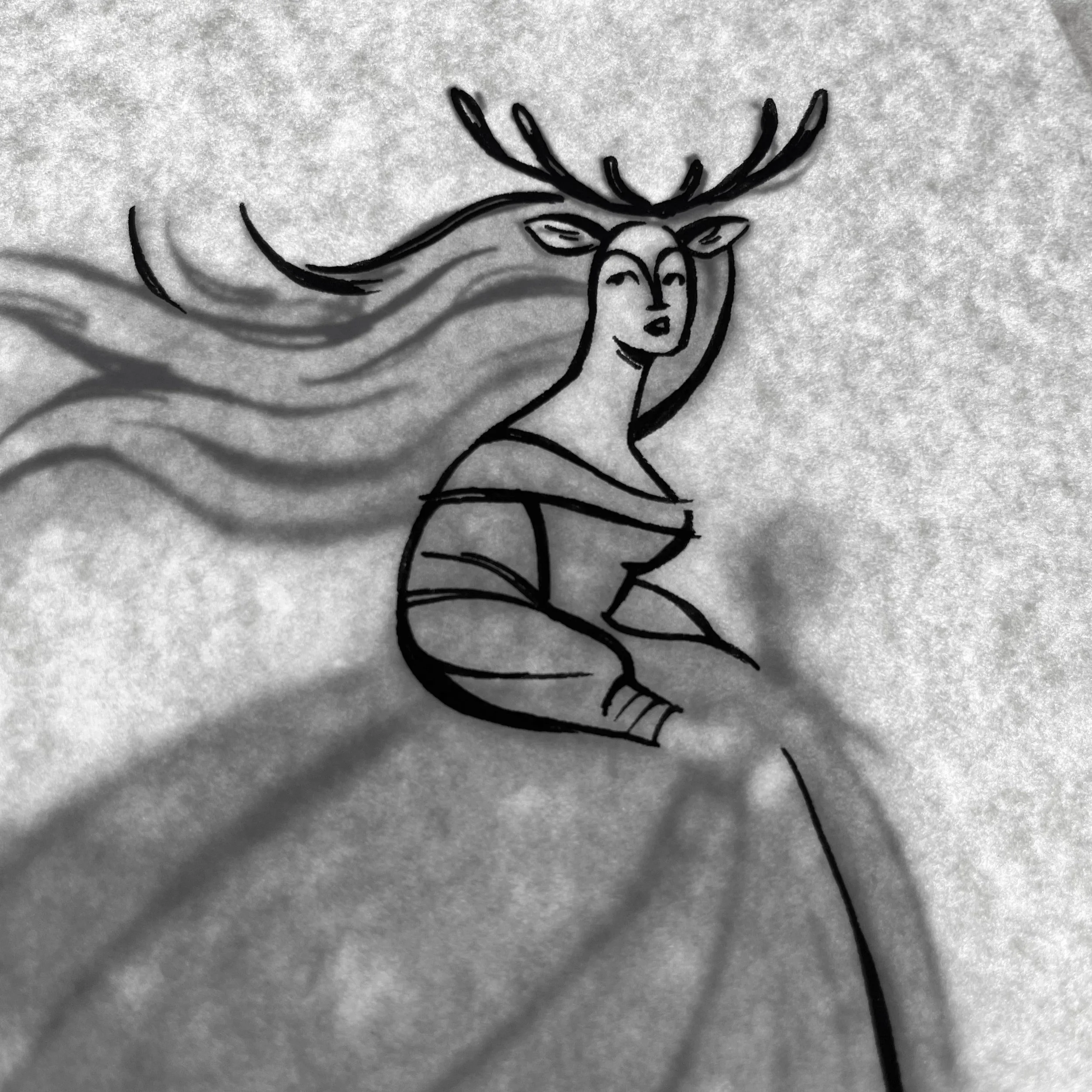 A close-up of a partially inked illustration of Lady Ada, a girl with long flowing hair and deer antlers and ears. Behind the paper with the final inks, the sketch is visible, demonstrating the lightbox technique.
