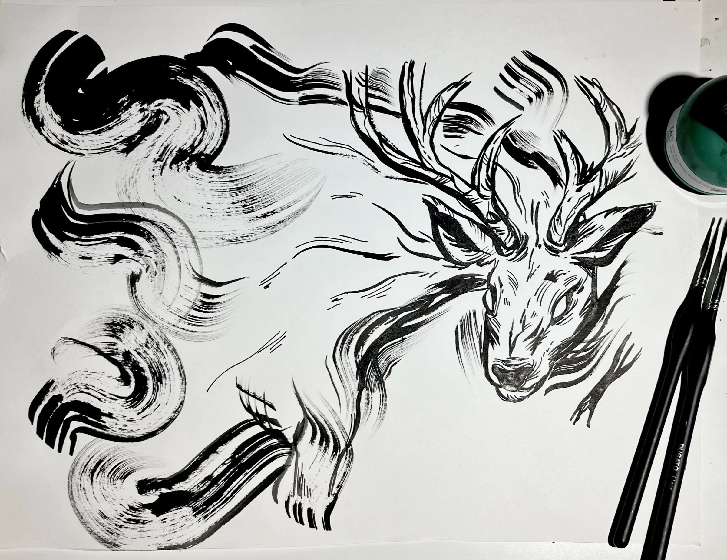 A process ink illustration of an intimidating stag. The bust fades into abstract ink swirls. The brushes and ink used are on the side of the photo. Black and white.