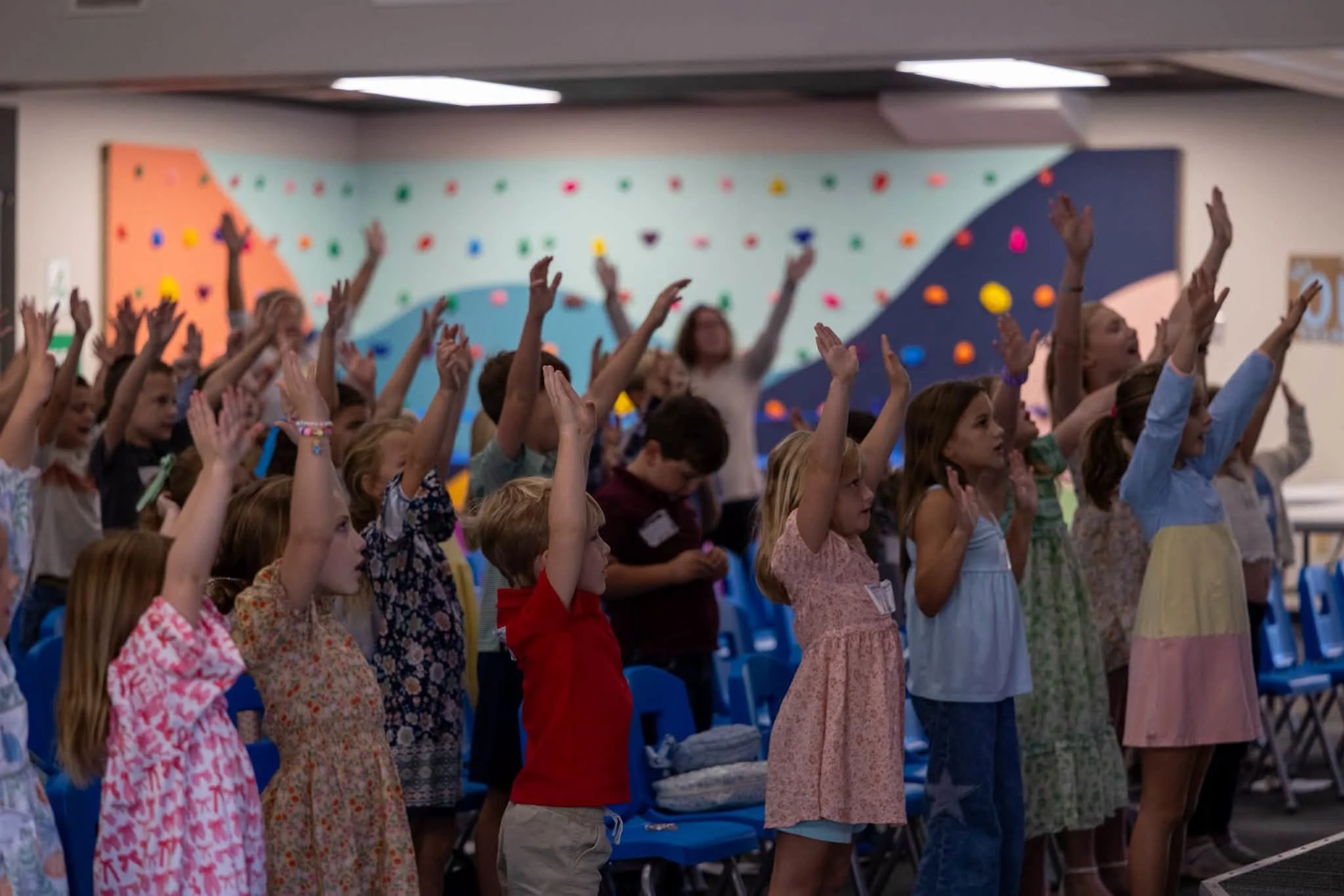 Kids raising their hands in worship during Central Kids