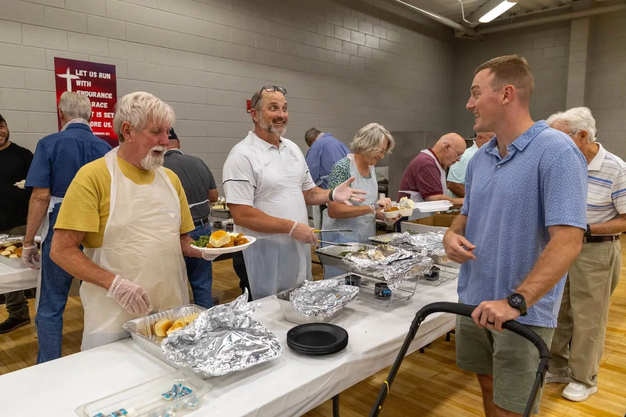 Men of Central Baptist serving food together at a fellowship meal