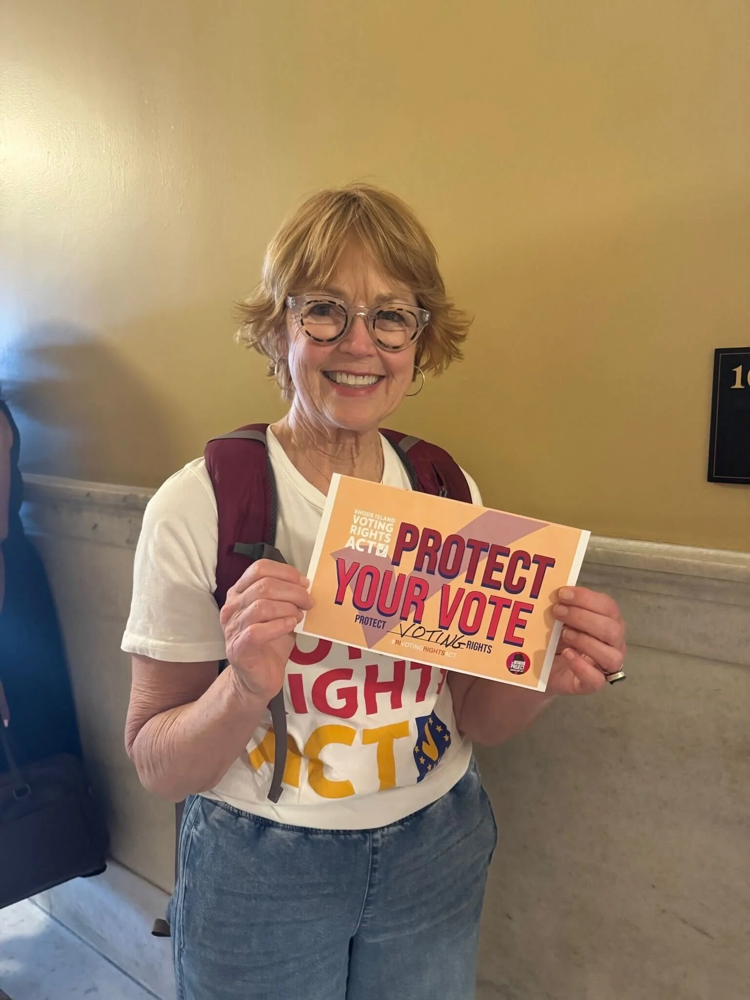 Supporter holds "Protect Your Vote" postcard