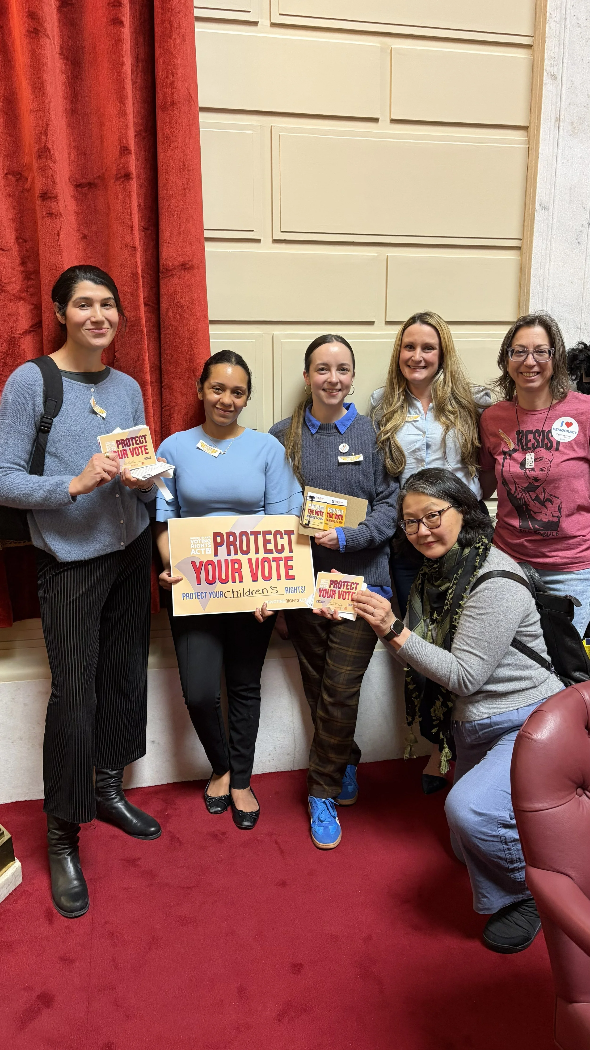 Advocates hold "Protect Your Vote" Signs on the House Chamber floor