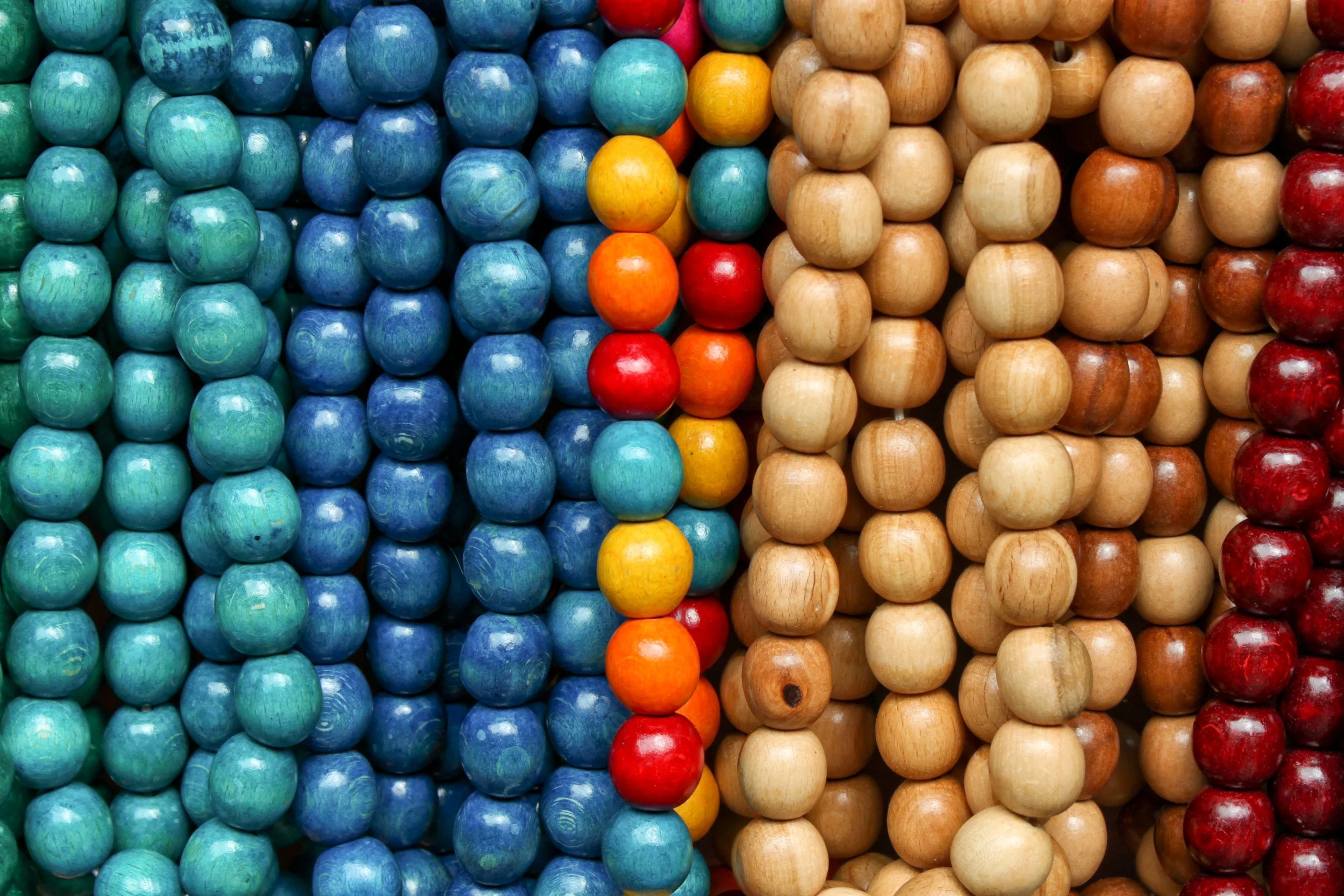 Display of colorful wooden beads arranged in vertical rows.