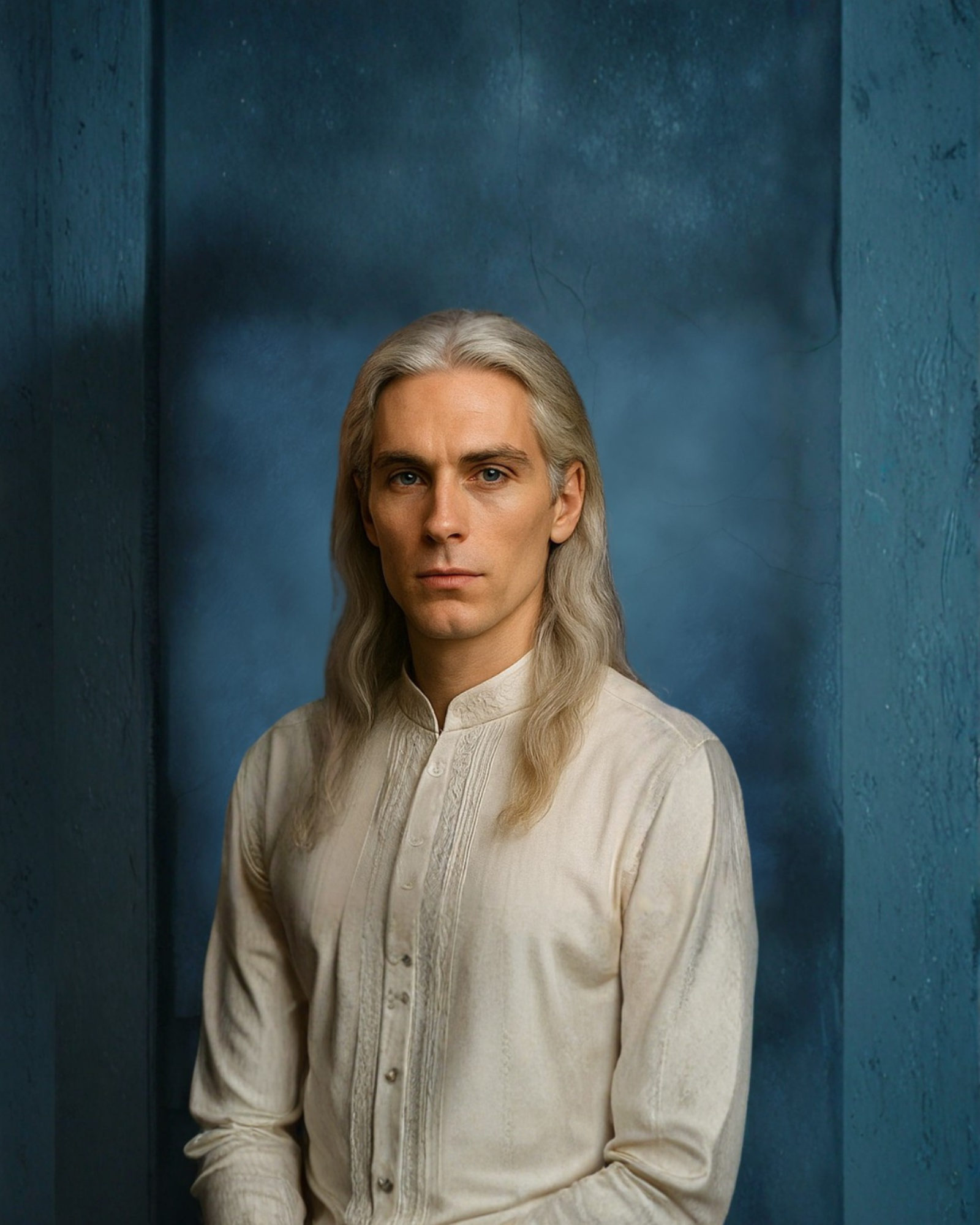 Portrait of a man with long silver hair, wearing a cream-colored, button-up shirt, standing against a textured blue background.