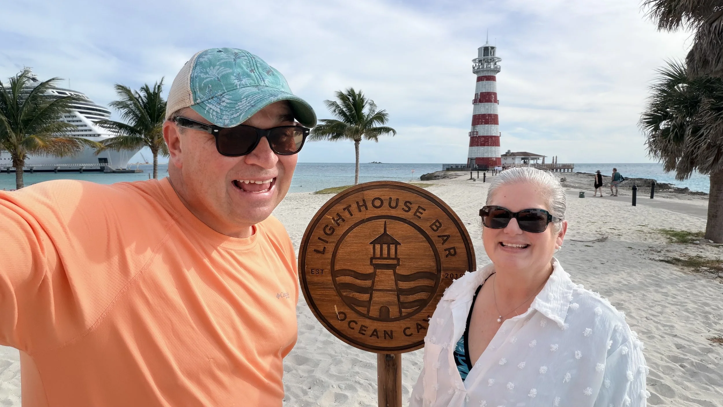 Michael and Tiffany standing on beach in front of lighthouse on MSC Ocean Cay island
