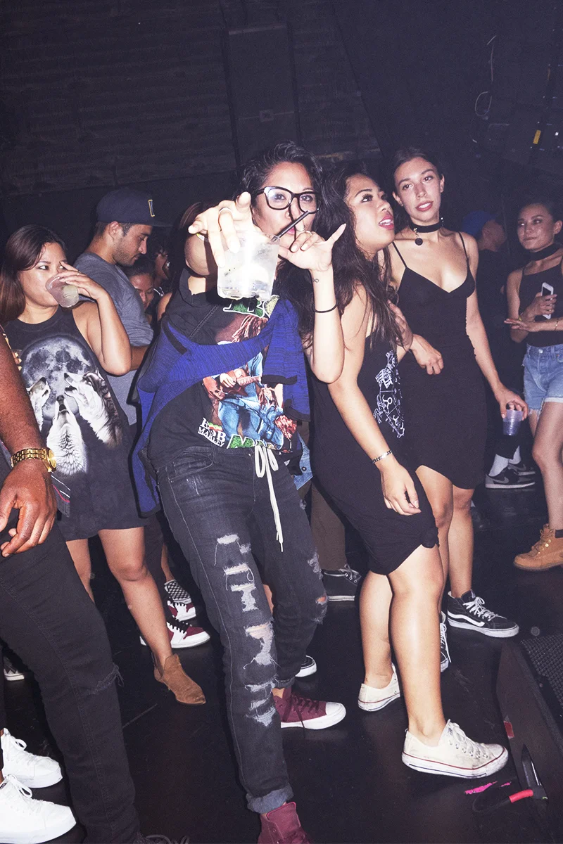 Group of young women at a party or nightclub, standing and dancing.