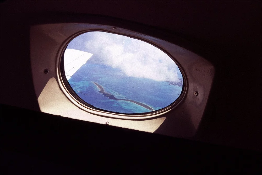 View of a body of water and islands seen through an airplane window