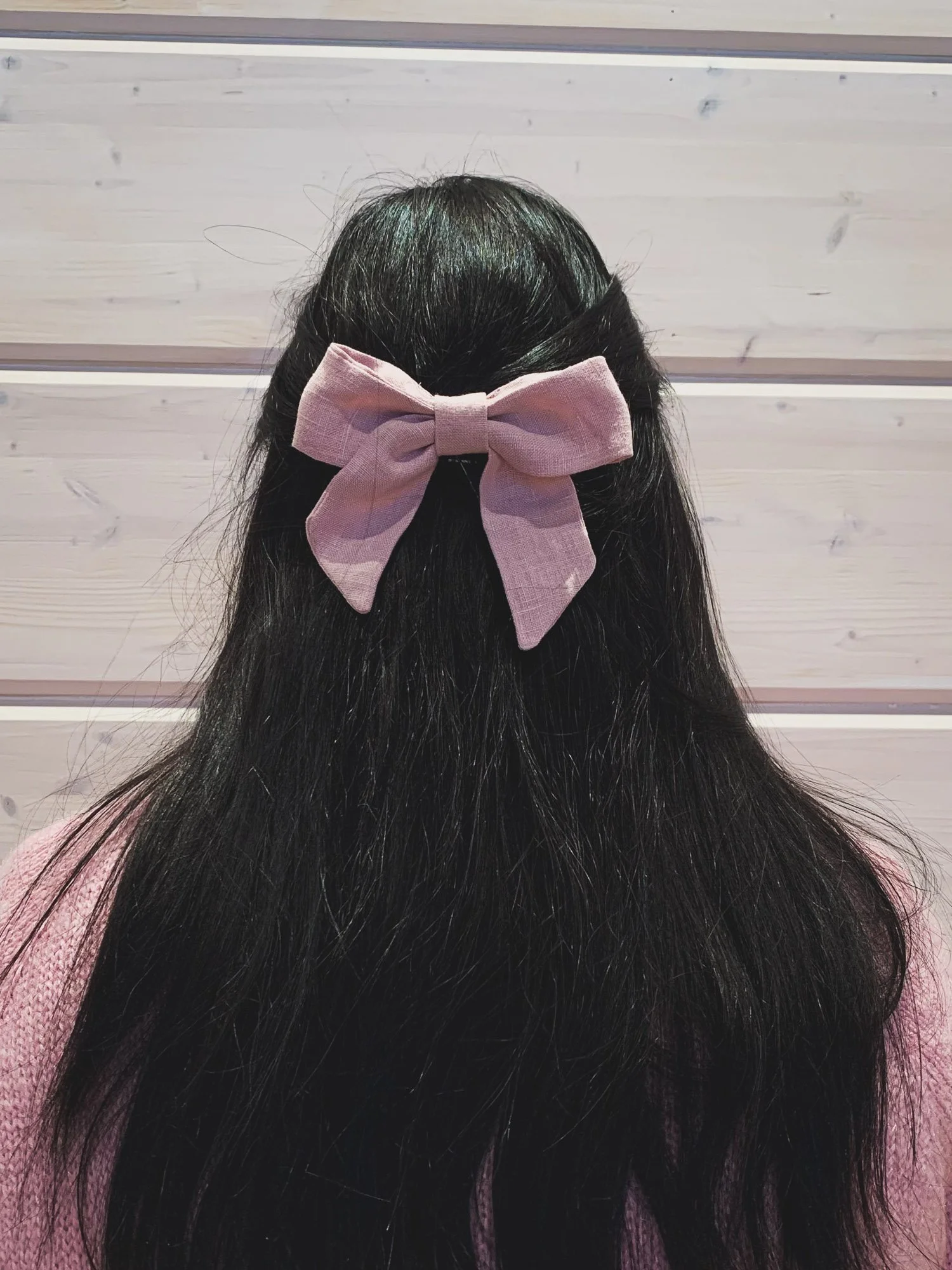 Vaaleanpunainen pellavarusetti hiuksissa.