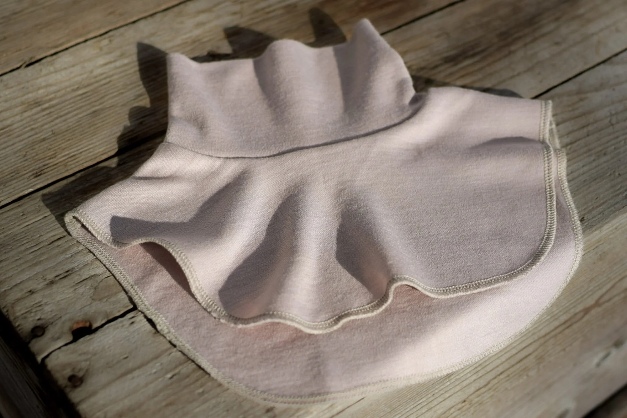 Vaaleanpunainen merinovillakauluri lapselle.