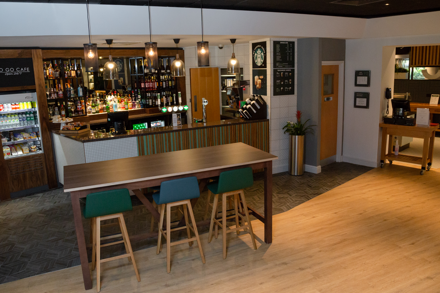 Interior of a modern coffee shop with a bar, seating area, and menu boards