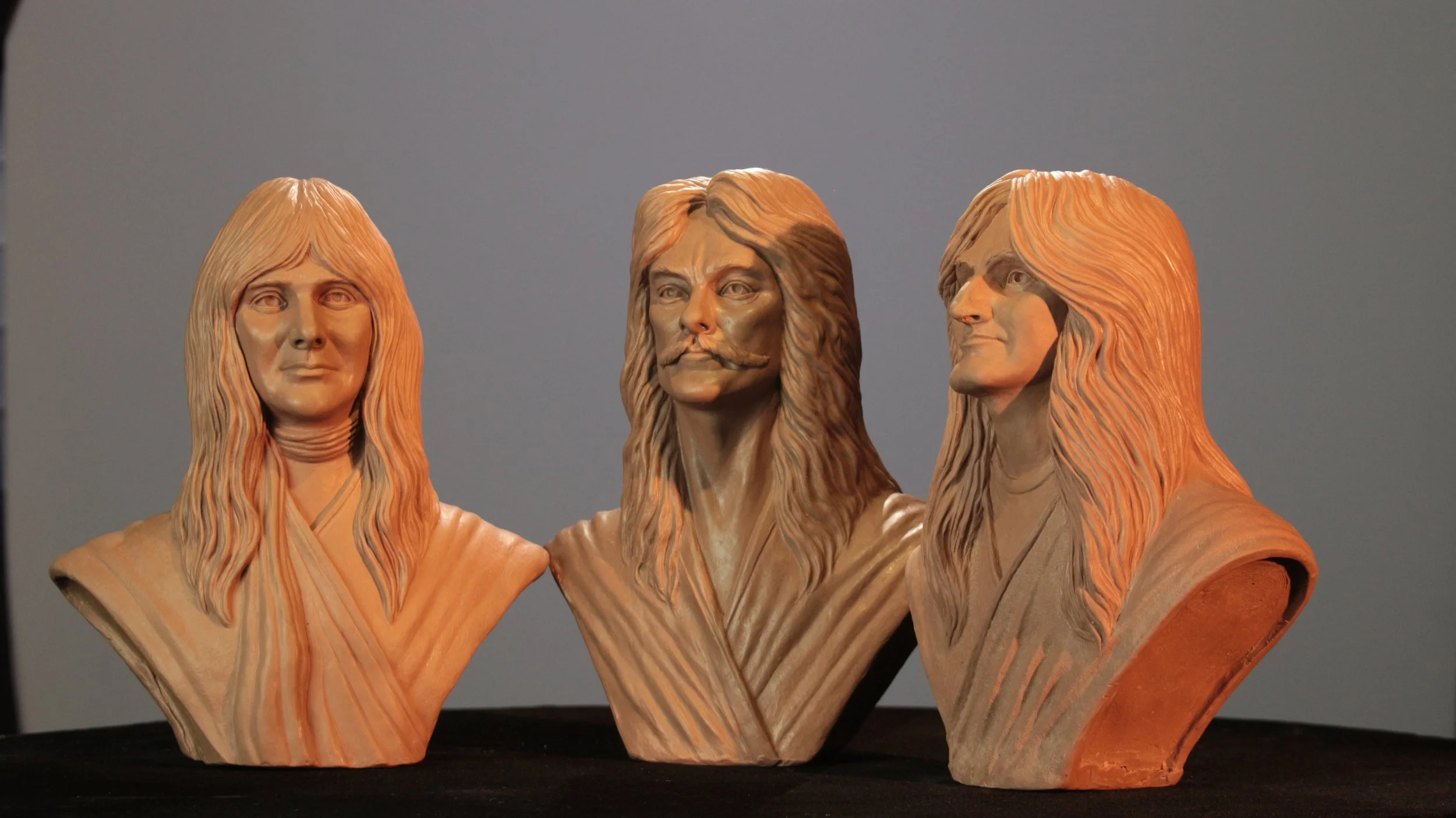 Three wooden sculptures of Jesus Christ with long hair and beards, shown from different angles, against a plain background.