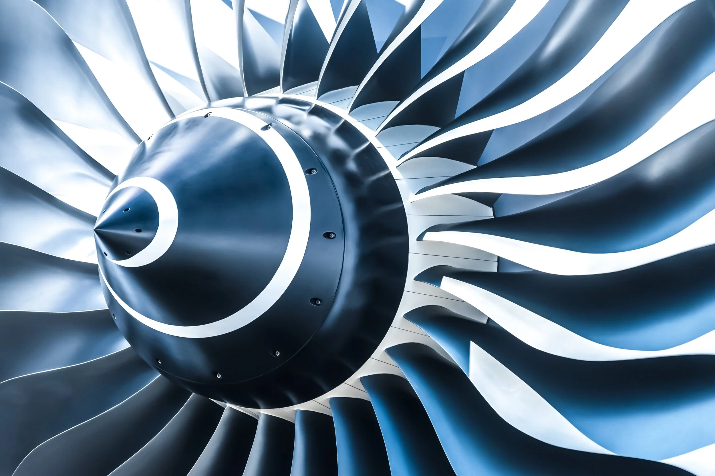 Close-up of turbine blades in a jet engine with shiny metallic surface and sleek design.
