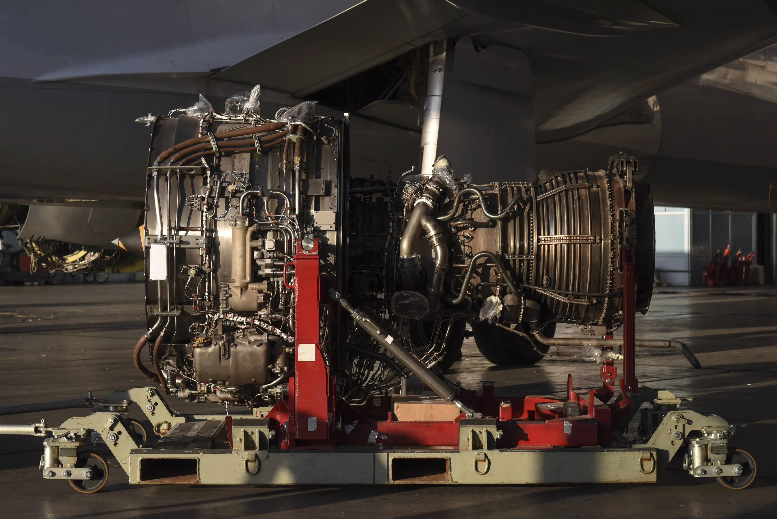 Close-up of aircraft engine components on a maintenance stand outdoors.