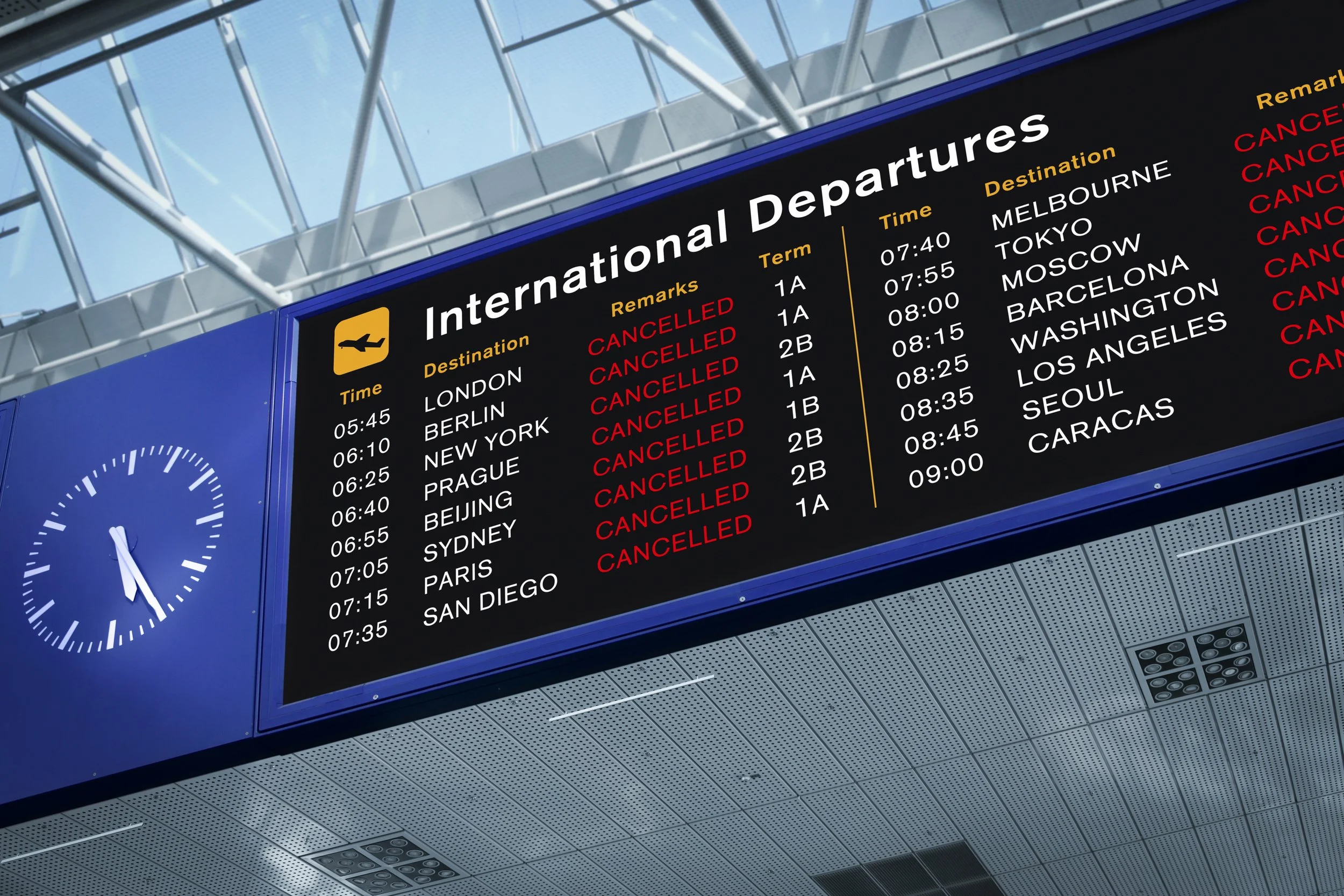 Digital airport departure board displaying flight times, destinations, and cancellations.
