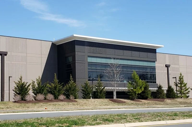 Modern multi-tenant data center facility with glass and grey industrial siding in Ashburn, Virginia.