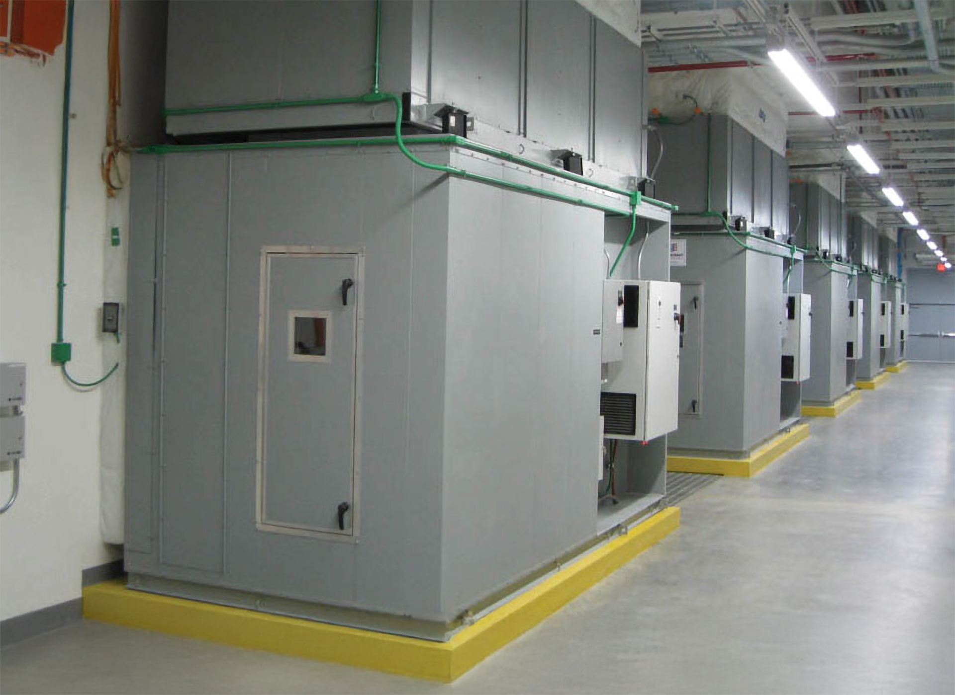 Row of gray DataCool fan coil wall units with integrated control panels in a hyperscale data center.